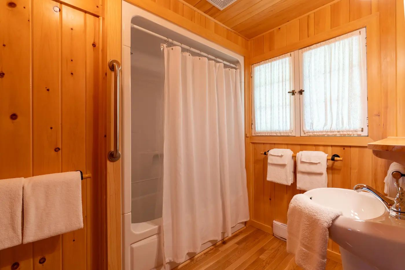 Cabin pine-clad washroom with bath.