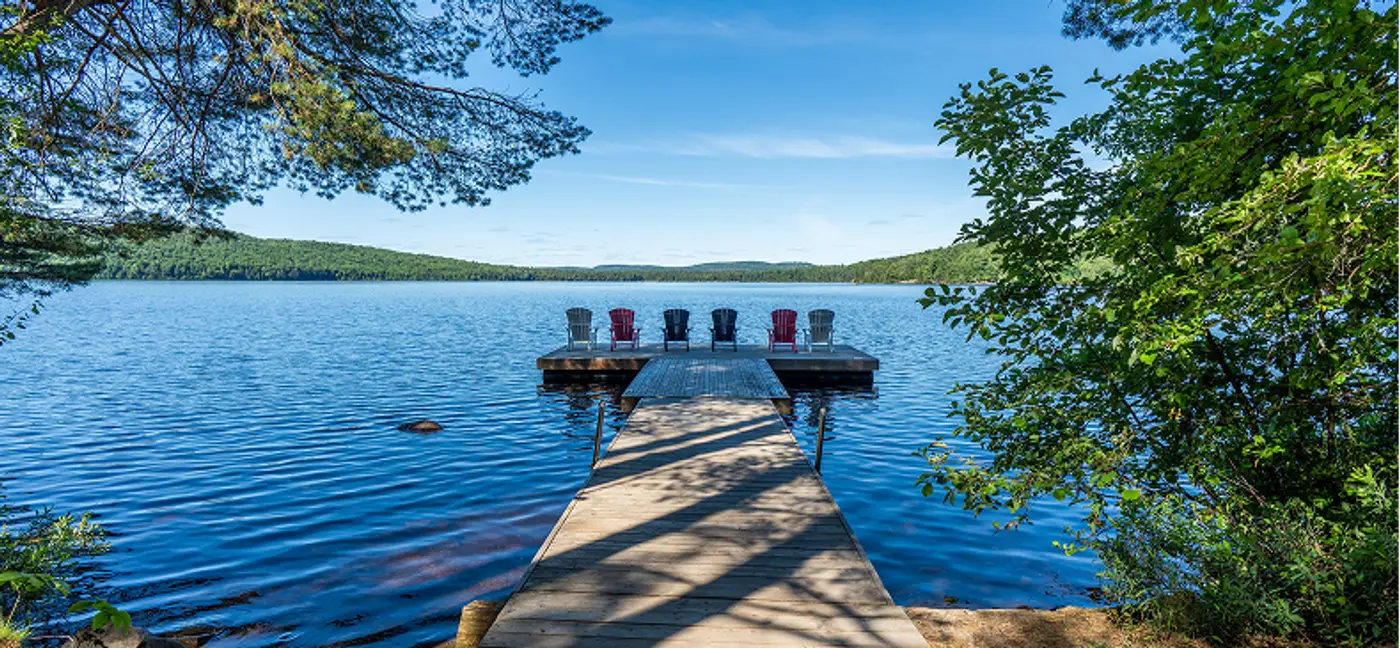 A walk out dock with colorful recliners on the Lake of Two Rivers at Killarney Lodge in Algonquin Park.