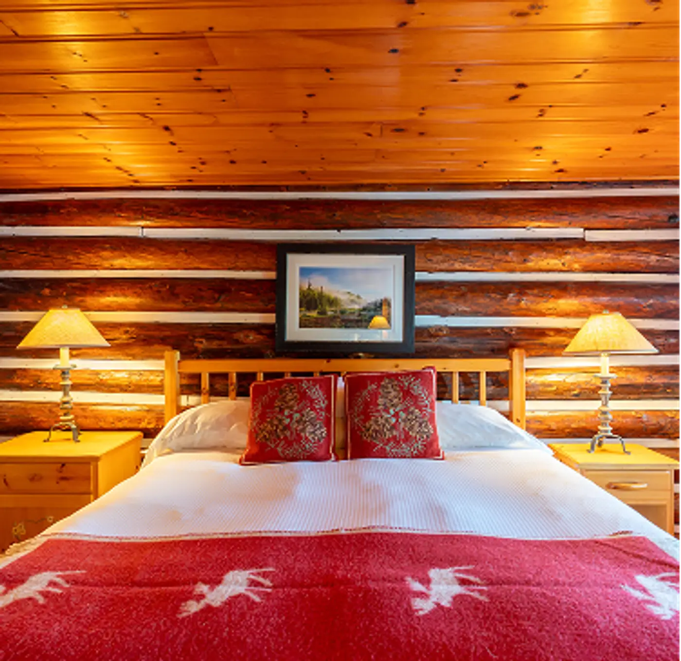 Cabin bedroom featuring log interior at Killarney Lodge in Algonquin Park.
