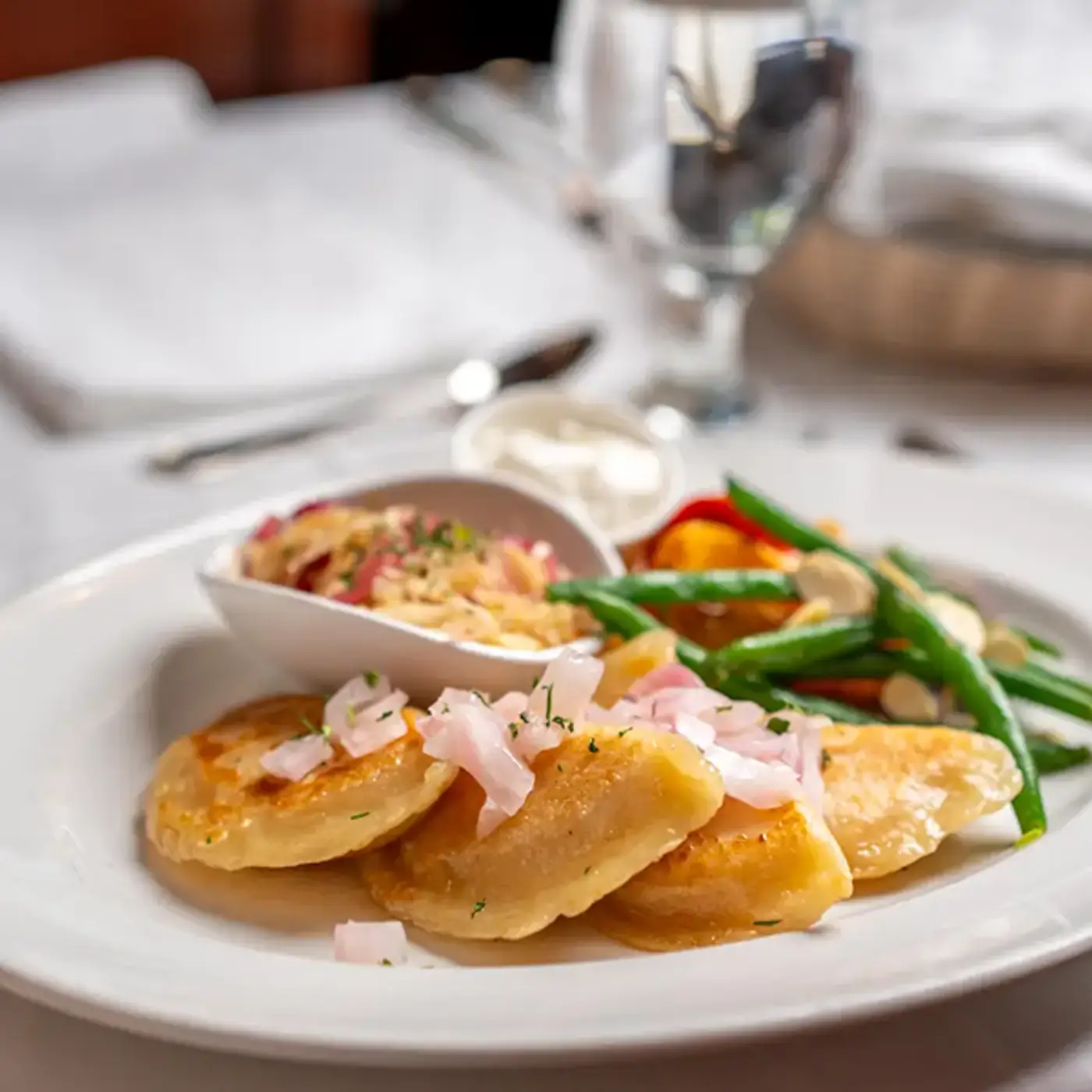 Golden crispy pierogies with caramelized red onion and fresh steamed veggies at Killarney Lodge in Algonquin Park.